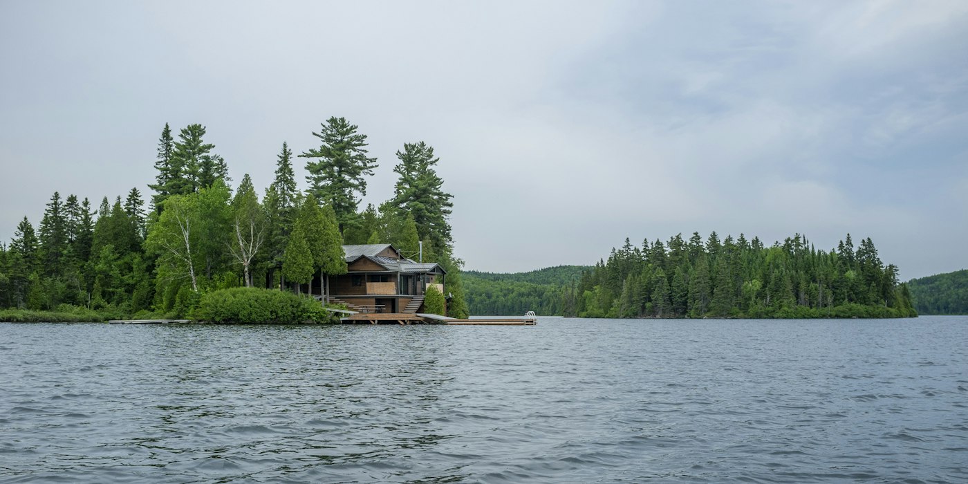 Lakefront cottage with a dock among pine trees
